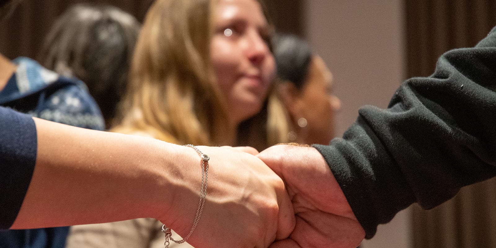 Teilnehmerin mit Tränen der Erkenntnis beim Fokus Mind Retreat, zwei Hände halten sich